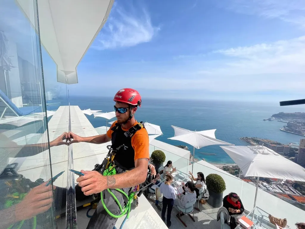 Film miroir posé sur le garde-corps vitré d'un balcon au-dessus de Monaco